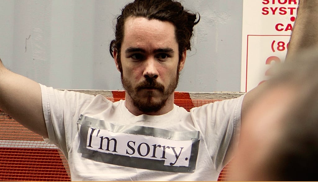 Man wearing a T-shirt that says "I'm sorry"