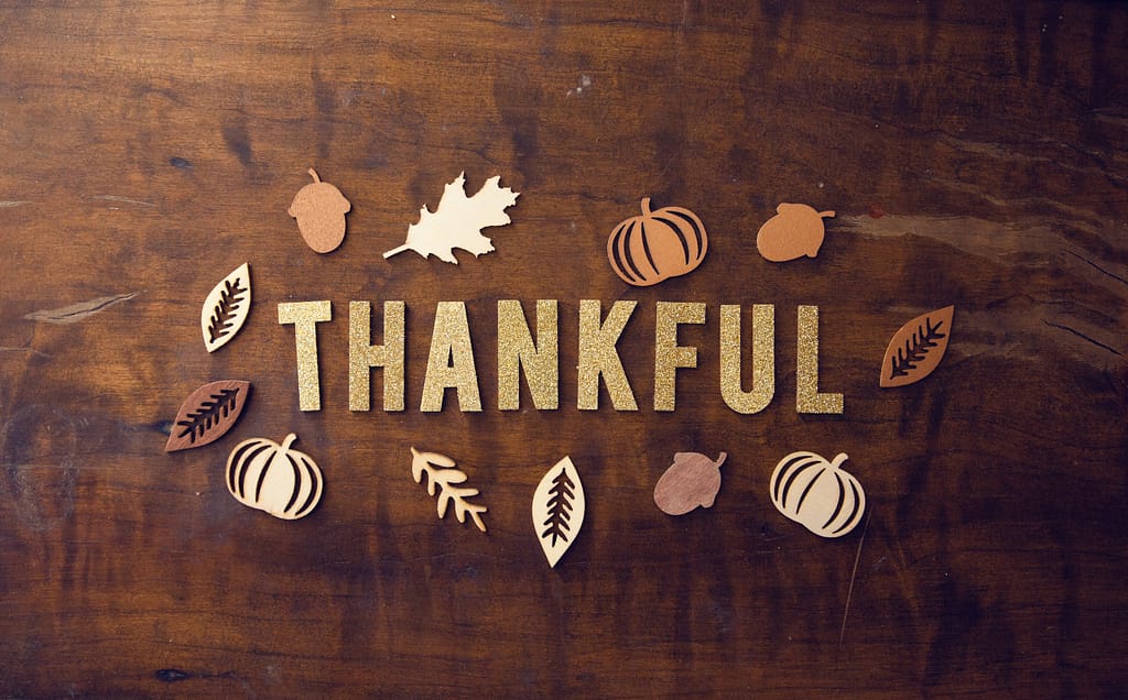 The word "Thankful" is written on an oak table -11 Simple Ways to Be Your Very Best