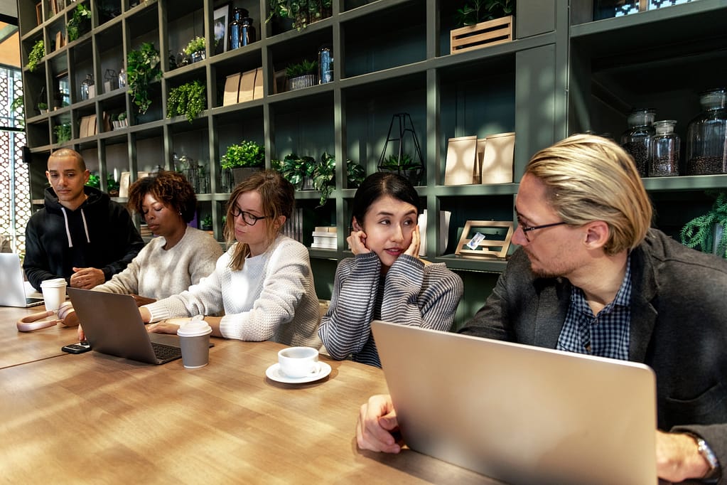 Strangers sitting at a coffee shop bench interacting between each other - 11 Simple Ways to Be Your Very Best