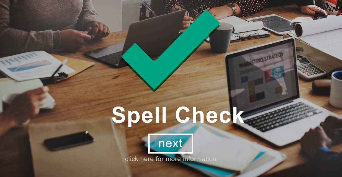 A desk with 2 laptops on it with the words "Spell Check" and a button "next" - Top 11 Helpful Actions To Take After Publishing Your New Blog Post