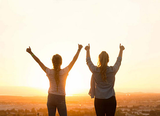 Two women with hands raised, happy with their achievement - 11 Simple Ways to Be Your Very Best