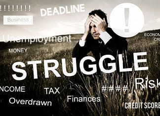 Businessman sitting in a field with hands on his face and words of struggle, deadline, finances, etc. printed all over