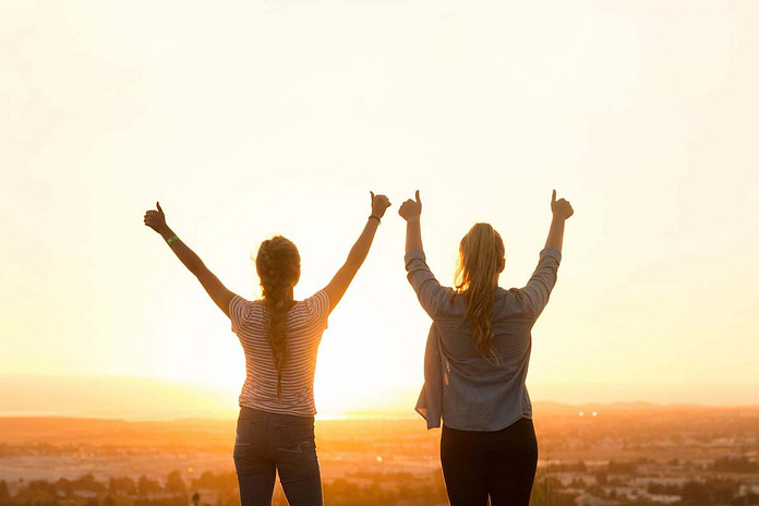 Two women with hands raised, happy with their achievement - 11 Simple Ways to Be Your Very Best