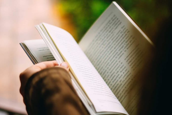 Person reading book - image shot from over person's head - Top 5 Reasons People Should Read Daily