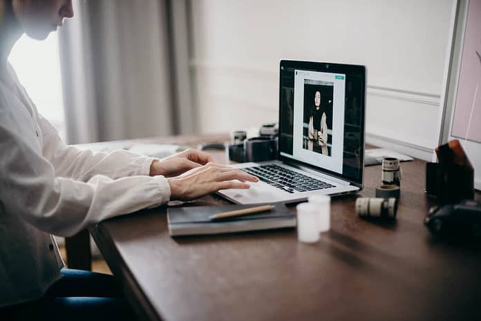 Image of woman's hands on a laptop editing an image - how to optimize images without losing quality