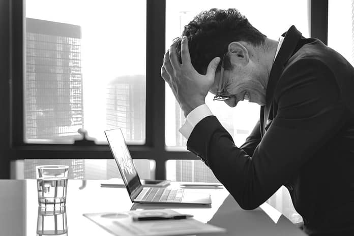 frustrated man at his desk - Reasons Preventing You From Being More Successful