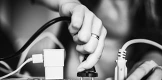 Person plugging in a device onto a surge protector