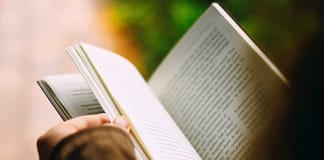 Person reading book - image shot from over person's head - Top 5 Reasons People Should Read Daily