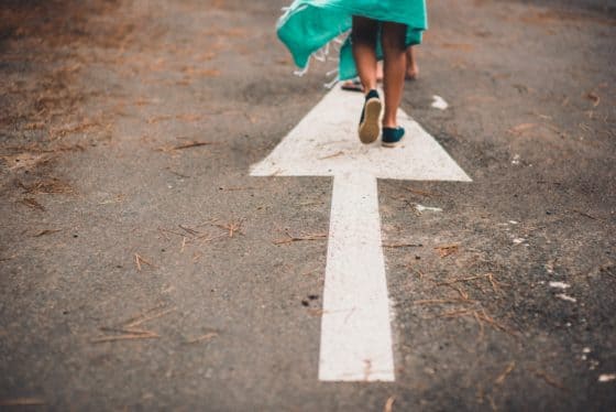 White Arrow pointing ahead and child walking in that direction - Making Money Online