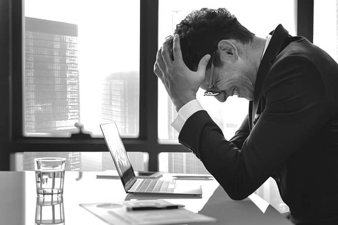 frustrated man at his desk - Reasons Preventing You From Being More Successful