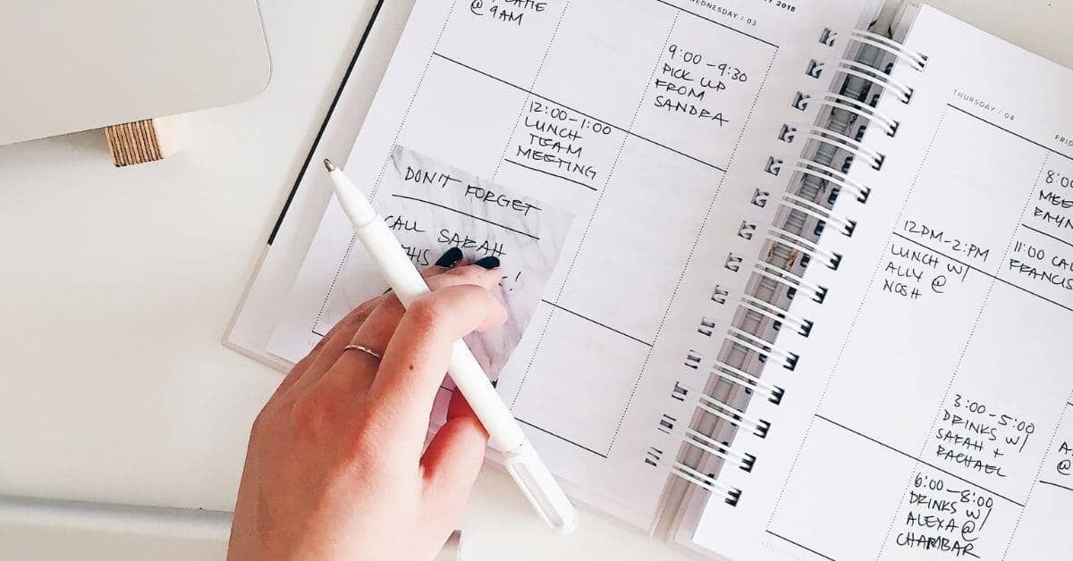woman's hand over a calendar, planning her week