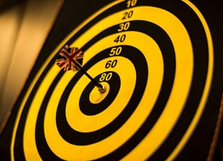 Bull's Eye with yellow dart in the center - Setting The Right Goals