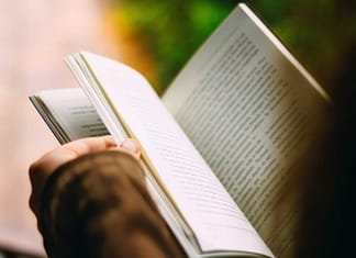 Person reading book - image shot from over person's head - Top 5 Reasons People Should Read Daily