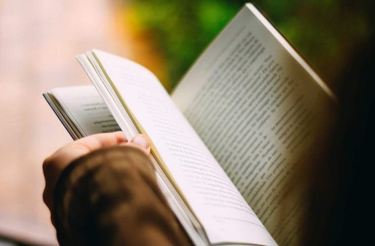 Person reading book - image shot from over person's head - Top 5 Reasons People Should Read Daily